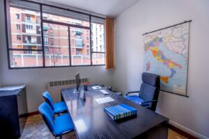fauteuil roulant noir à côté d'un bureau en bois noir avec écran plat