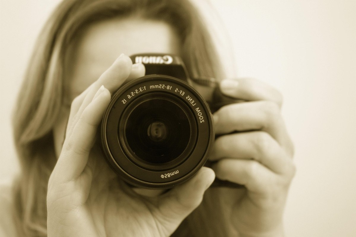 Une femme prend un auto-portrait avec un appareil photo Canon Une femme prend un auto-portrait avec un appareil photo Canon